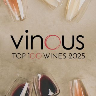 Overhead view of red and white wine glasses lying on their sides, with a text overlay in the center reading “Vinous Top 100 Wines 2025.”
