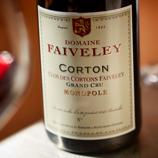 lose-up of the Domaine Faiveley Corton Grand Cru Clos des Cortons Faiveley (Monopole) wine label, showing the crest and detailed typography.