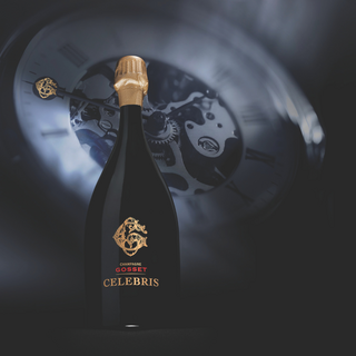Champagne Gosset Celebris bottle featured in a beauty shot, with a clock softly visible in the background.
