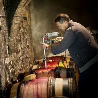Man standing in the cellars of Clau de Nell.
