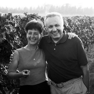 A black and white photo of Lucia Gaja and her husband Angelo Gaja in the vineyards candidly smiling.