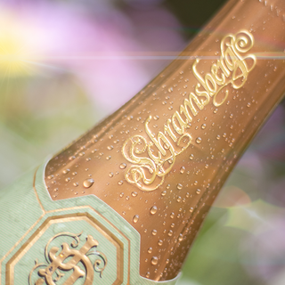 A close-up photo of Schramsberg's gold neck foil. It contains the scripted Schramsberg insignia on it.