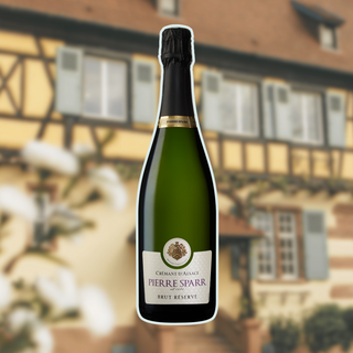 Bottle of Pierre Sparr Crémant d'Alsace Brut Réserve sparkling wine displayed in front of a blurred view of the Pierre Sparr winery.