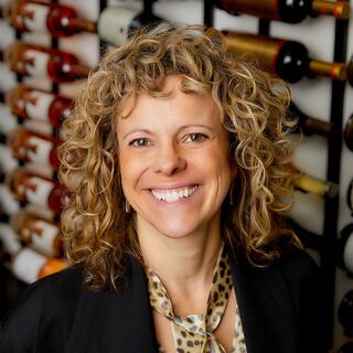 Vice President - Northeast Division Kristin Butke poses in the Wilson Daniels wine cellar, wearing a dark blazer and an animal print blouse.