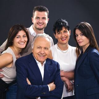 The Gaja family poses for a photo. Angelo Gaja, the fourth generation, is smiling while crossing his arms.